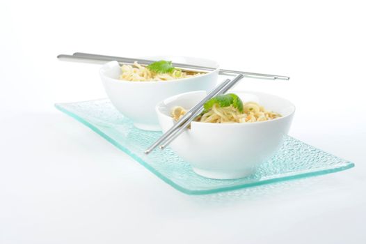 Bowls of oriental rice noodles with chopsticks.