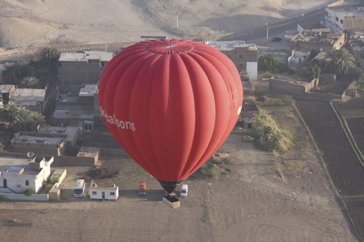 one red hot air balloon taking off in Luxor Egypt, aerial shot