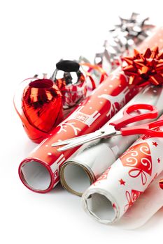 Rolls of Christmas wrapping paper with ribbons, bows and scissors