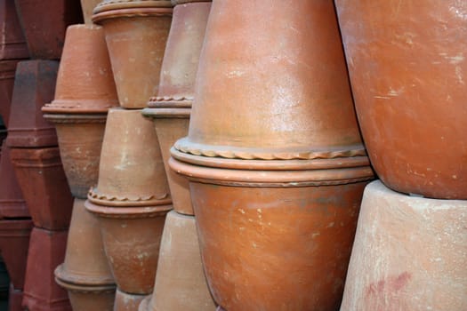 A stack of different red clay pots at a potters workshop.