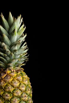 A fresh whole pineapple isolated on black