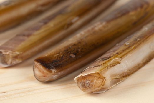 Fresh  razor clams on a wooden board