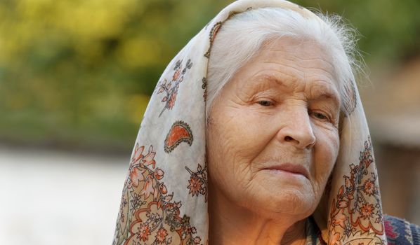 Portrait of the elderly woman. A photo on outdoors