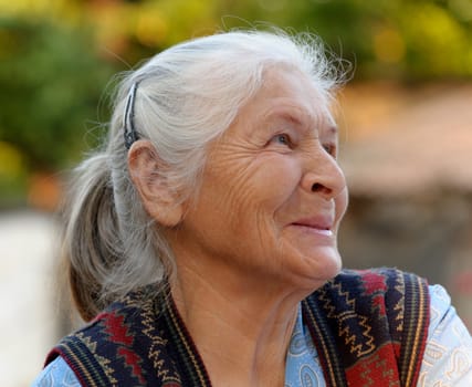 Portrait of the elderly woman. A photo on outdoors