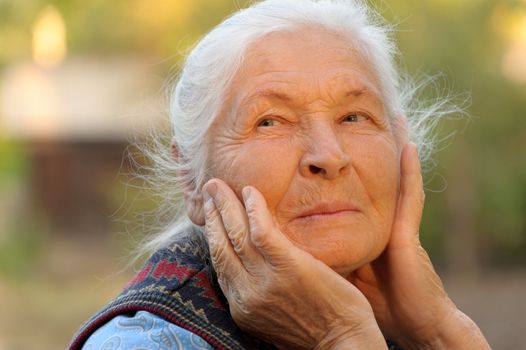 Portrait of the elderly woman. A photo on outdoors