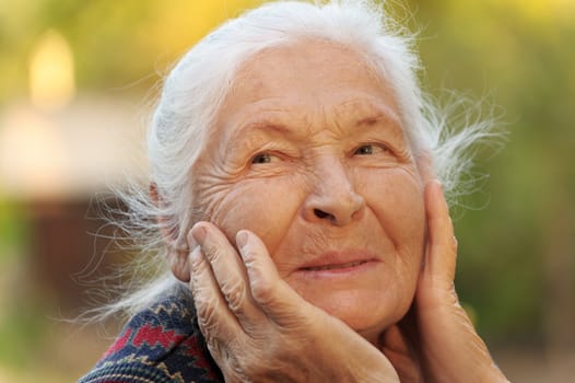 Portrait of the elderly woman. A photo on outdoors