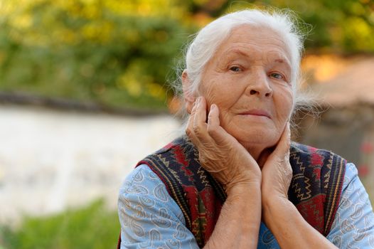 Portrait of the elderly woman. A photo on outdoors