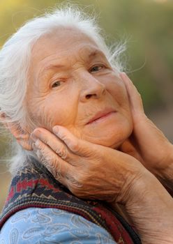 Portrait of the elderly woman. A photo on outdoors