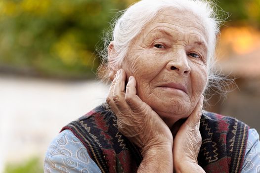 Portrait of the elderly woman. A photo on outdoors