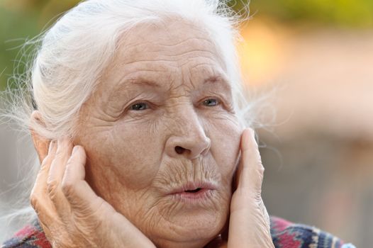 Portrait of the elderly woman. A photo on outdoors