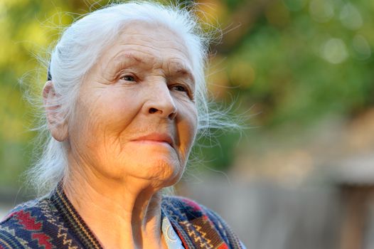 Portrait of the elderly woman. A photo on outdoors