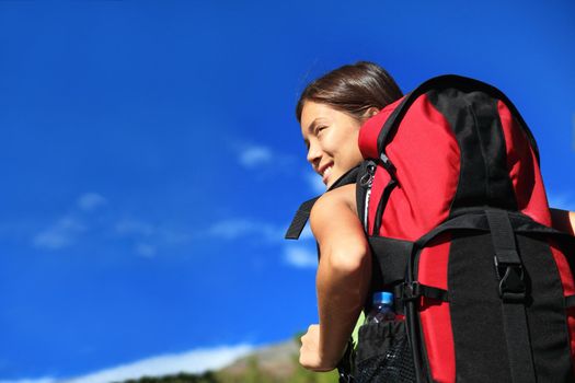 Hiker looking while backpacking / hikiking in nature. Copy space on blue sky. 