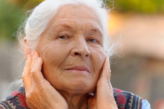 Portrait of the elderly woman. A photo on outdoors