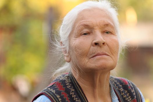 Portrait of the elderly woman. A photo on outdoors