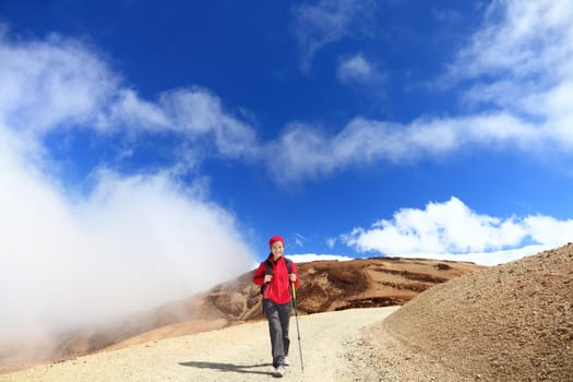 Hiker. Young woman hiking among clouds and blue sky. Beautiful outdoors person in walking on the volcano Teide, Tenerife, Canary Islands, Spain.