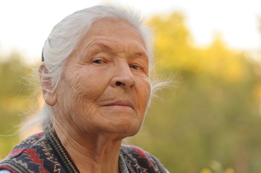 Portrait of the elderly woman. A photo on outdoors