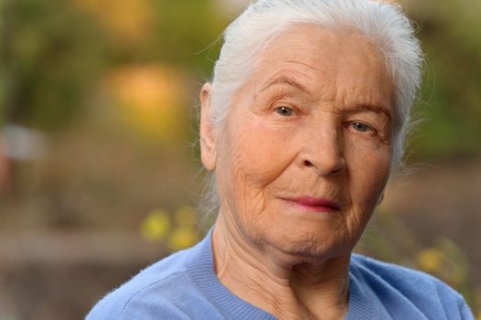 Portrait of the elderly woman. A photo on outdoors