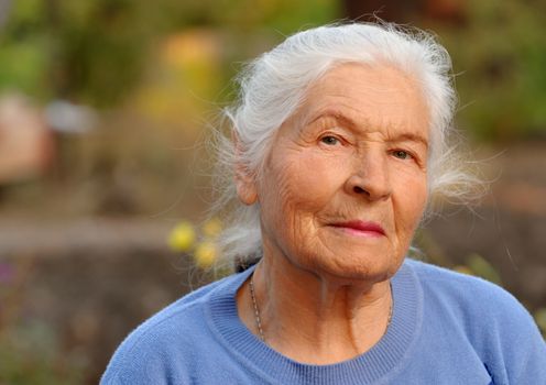 Portrait of the elderly woman. A photo on outdoors