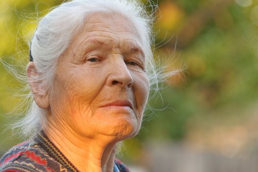 Portrait of the elderly woman. A photo on outdoors