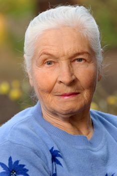 Portrait of the elderly woman. A photo on outdoors