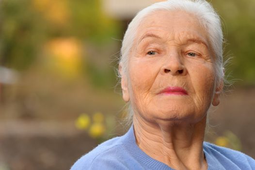 Portrait of the elderly woman. A photo on outdoors