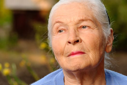 Portrait of the elderly woman. A photo on outdoors