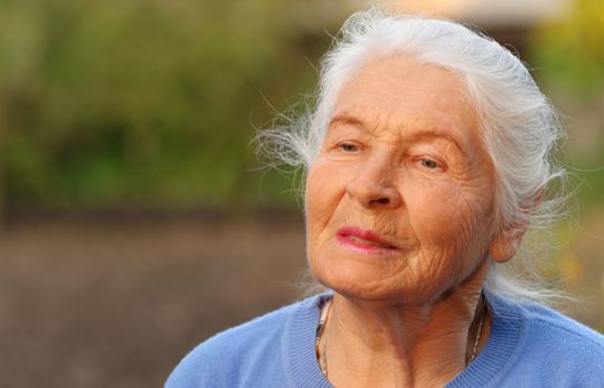 Portrait of the elderly woman. A photo on outdoors