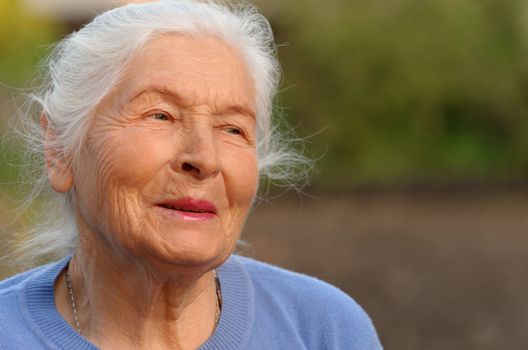 Portrait of the elderly woman. A photo on outdoors