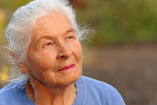 Portrait of the elderly woman. A photo on outdoors