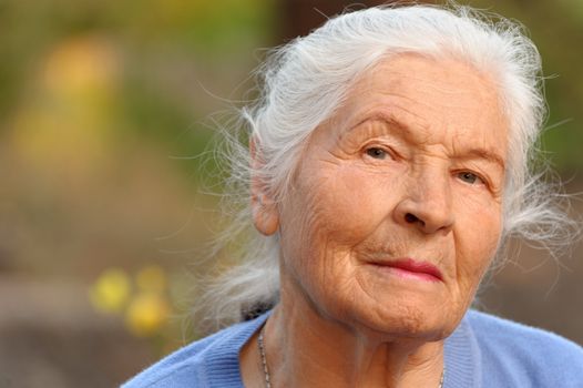 Portrait of the elderly woman. A photo on outdoors