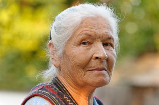 Portrait of the elderly woman. A photo on outdoors