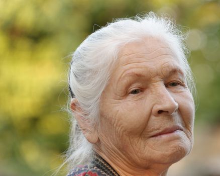 Portrait of the elderly woman. A photo on outdoors