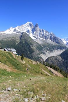 View of the Mont-Blanc massif behind a little house in the mountain by beautiful weather, Chamonix, France