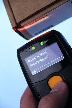 hand is holding a handheld barcode scanner