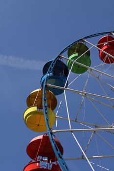 Ferris wheel close up over blue sky.