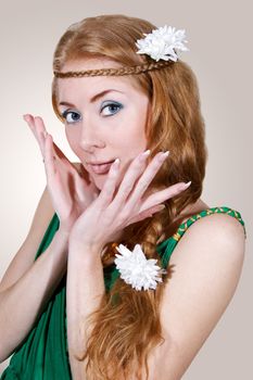 Red-headed woman in green dress touching her face