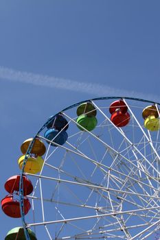 Ferris wheel close up over blue sky.