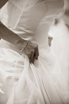 Sepia Picture of a Bride tryng on her Gown