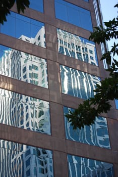 Office building reflecting in another building window in business center of city