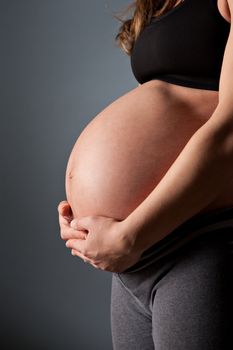 Young pregnant woman holding her belly