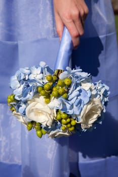 Bridesmaid holding blue flowers in her hand