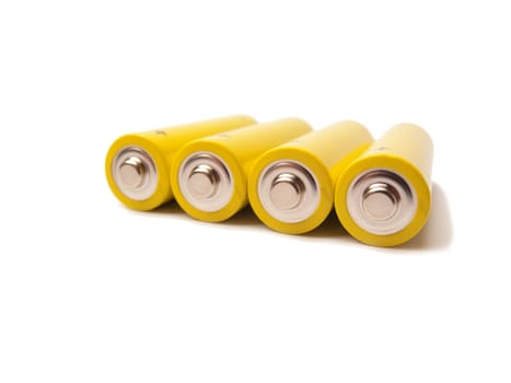 Four yellow batteries with the contacts showing, white background