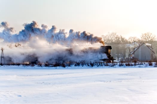 Vintage steam train starting from the station, wintertime
