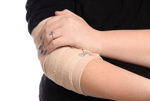 Closeup view of a young girl holding her  injured elbow, isolated on a white background.