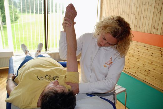 SAALFELDEN, AUSTRIA - AUGUST 30: physical therapist exercising with senior rheumatism patient on August 30, 2007 at rehabilitation center in Saalfelden, Austria.