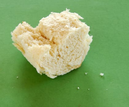 piece of white bread without crust over green background