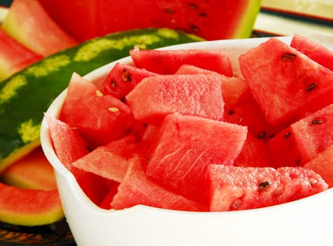 fresh appetizing ripe red watermelon pieces in white bowl