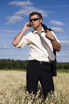 A businessman dressed in a smart suit standing on grass