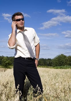 A businessman dressed in a smart suit standing on grass