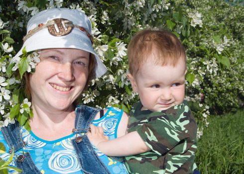 Mother and boy beside flowering aple tree.lucky family